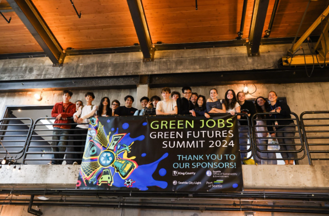 Group of people holding a sign that reads Green Jobs Green Futures summit.