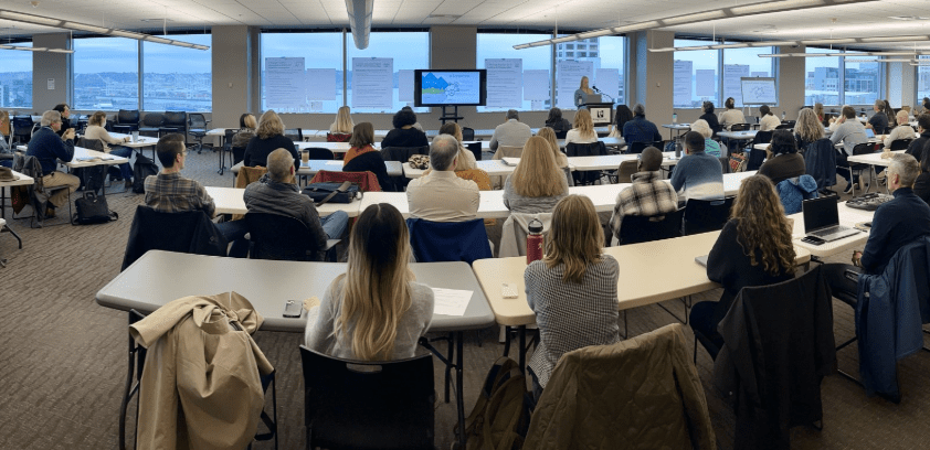 Group of people sitting in a room for SCAP workshop.