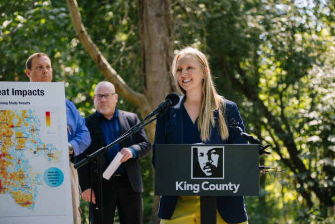 Climate Director Marissa Aho stands behind a podium with a King County logo on it.